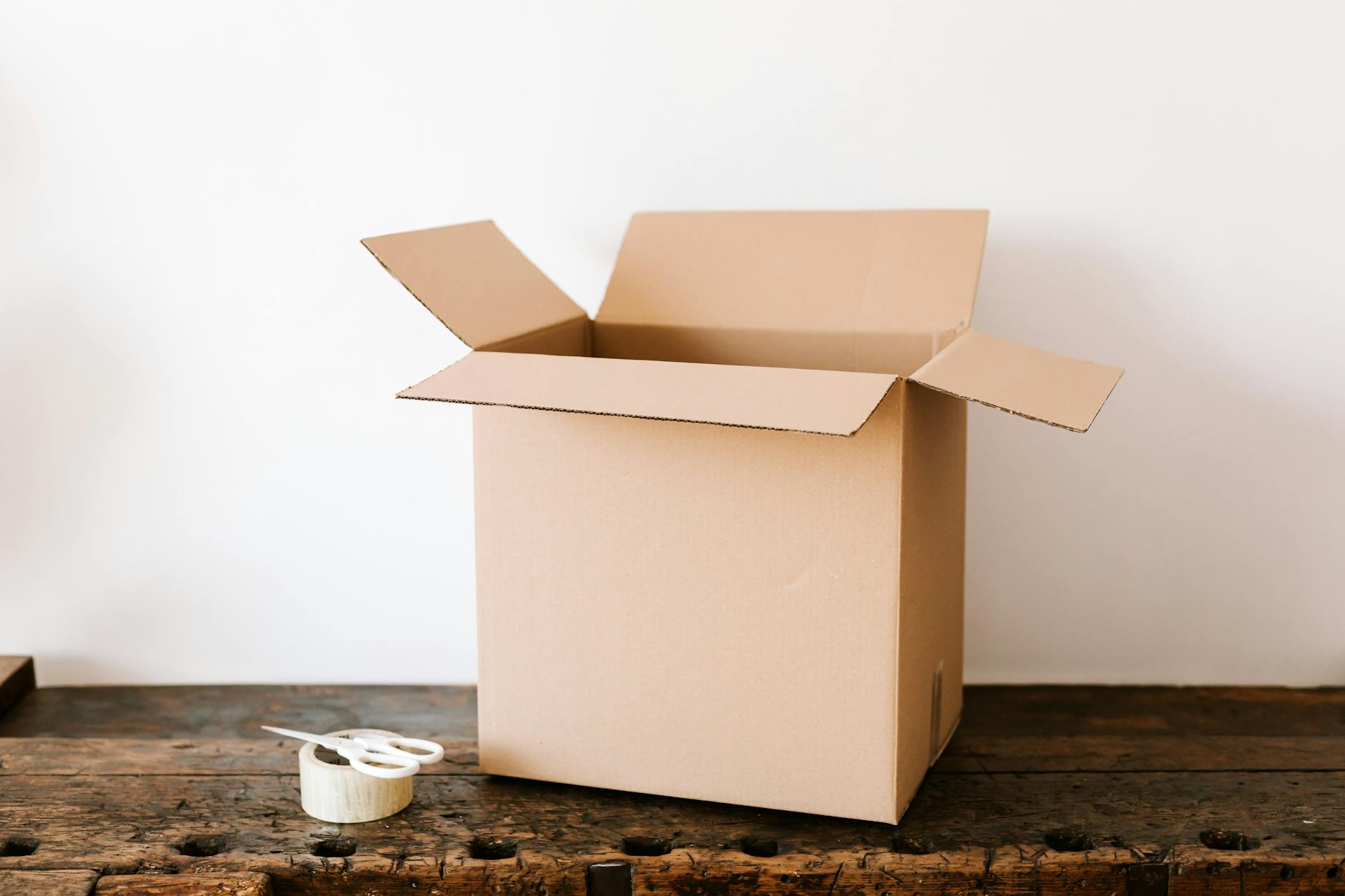 An open moving carton with tape, ready to pack